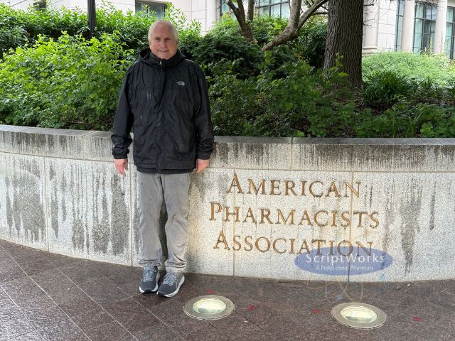 Bob Brensel in front of American Pharmacists Association Sign