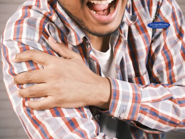 Man Grimacing While Holding His Shoulder in Pain